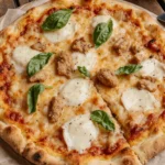 Low-carb chicken crust pizza topped with gooey mozzarella, crispy chicken bites, tomato sauce, and fresh basil – keto-friendly and gluten-free.