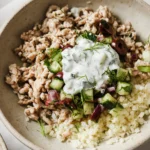 healthy ground chicken bowl with cucumber salad, tzatziki, and cauliflower rice