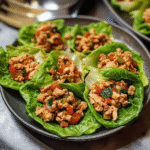 Healthy ground chicken lettuce wraps with vegetables served on crisp lettuce leaves