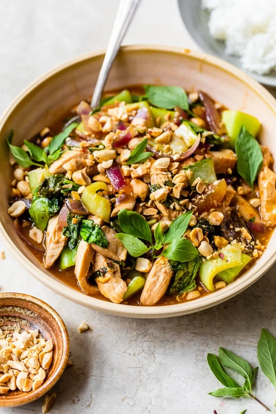 Thai basil chicken stir-fry with vegetables and crushed peanuts in a bowl.