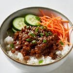 Korean inspired ground beef rice bowl with cucumbers and sesame