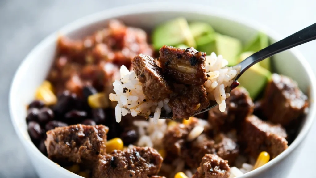spoonful of ground beef and rice over taco bowl